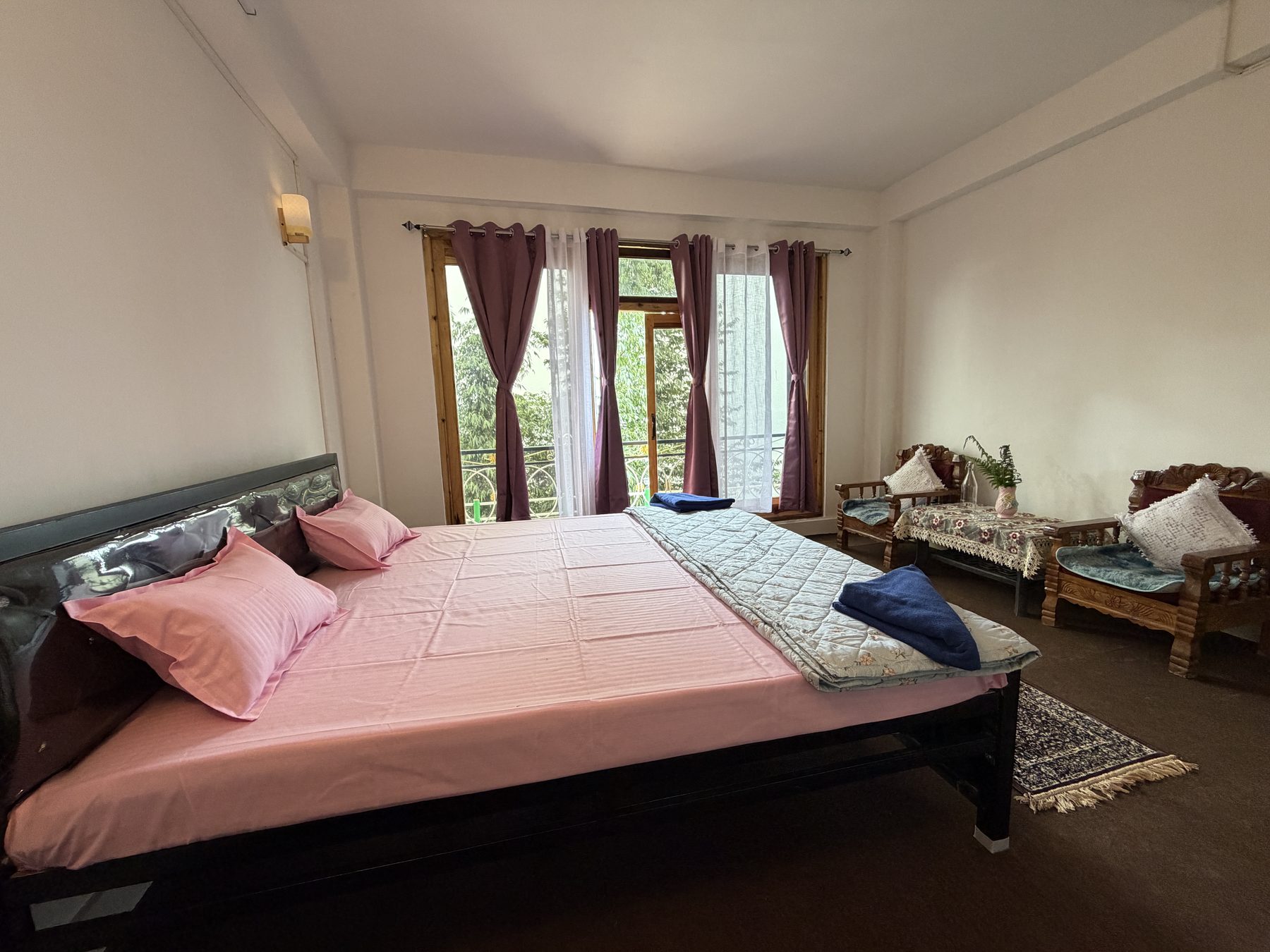 King bedroom with balcony and sitting corner at Kepchaki Stay homestay in Lamahatta, Darjeeling